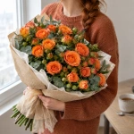 Девушка держит в руках букет из кустовых роз Солнечный апельсиновый поцелуй