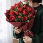 Букет красных тюльпанов, 101 шт. в руках у девушки