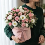 Цветы в коробке Малиновое очарование с розами и эустомой в руках у девушки