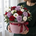 Цветы в коробке Розы и гвоздики в фиолетовом сиянии в руках у девушки